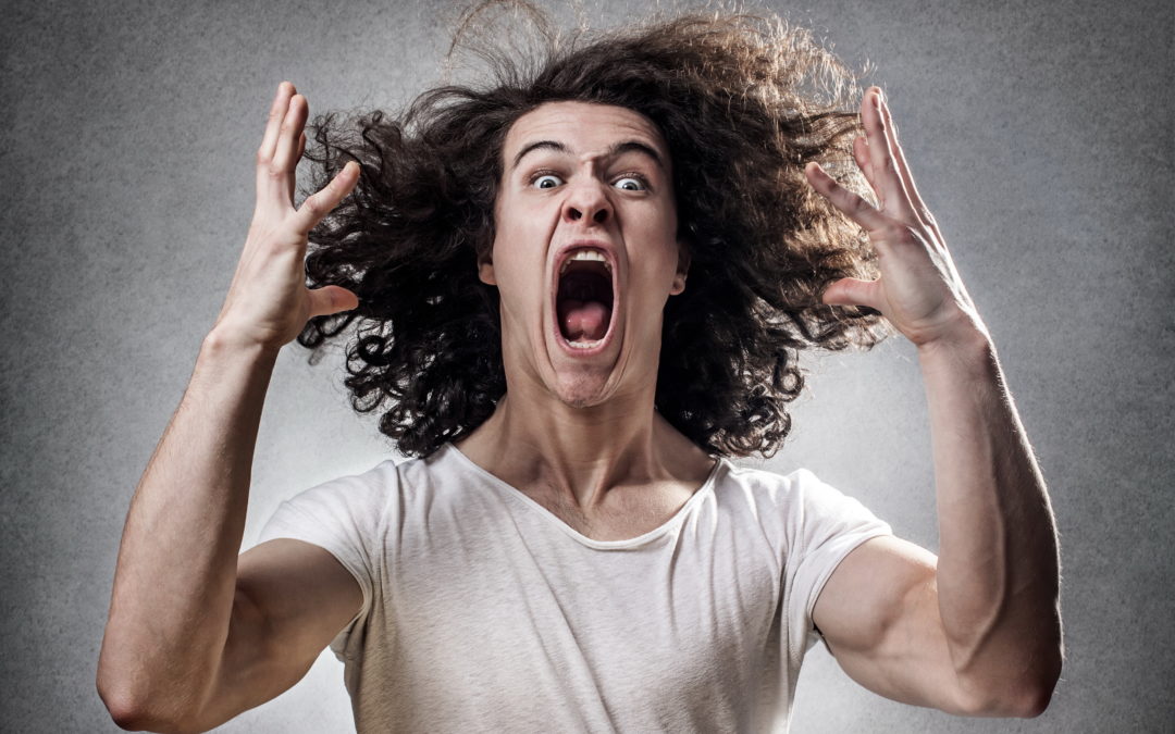 man screaming with his hair poofed out with hands in the air