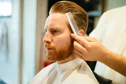 man getting hair combed by hairstylist